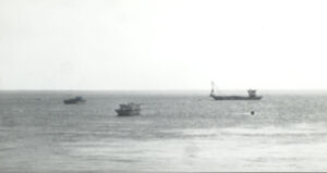 image noir et blanc, la mer et des bateaux au loin