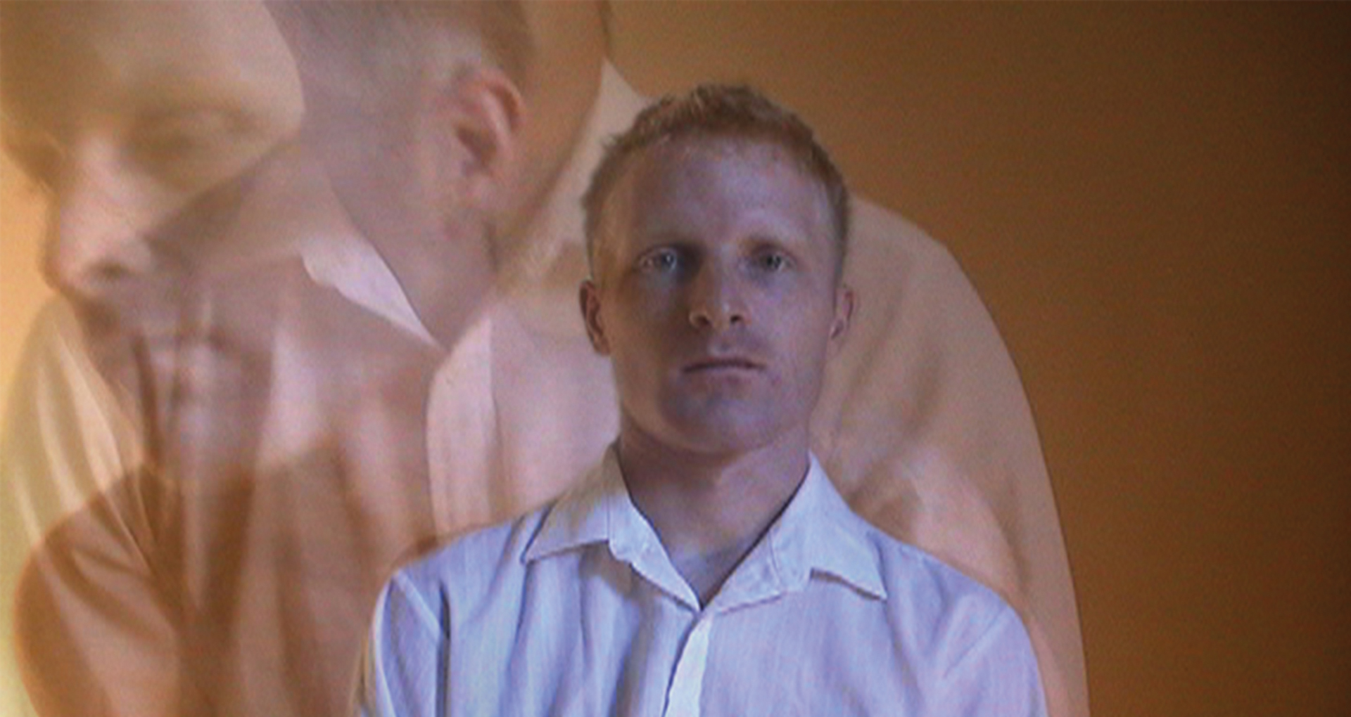Portrait en couleur d’un homme blond en chemise blanche. Se superposent des images en transparence.