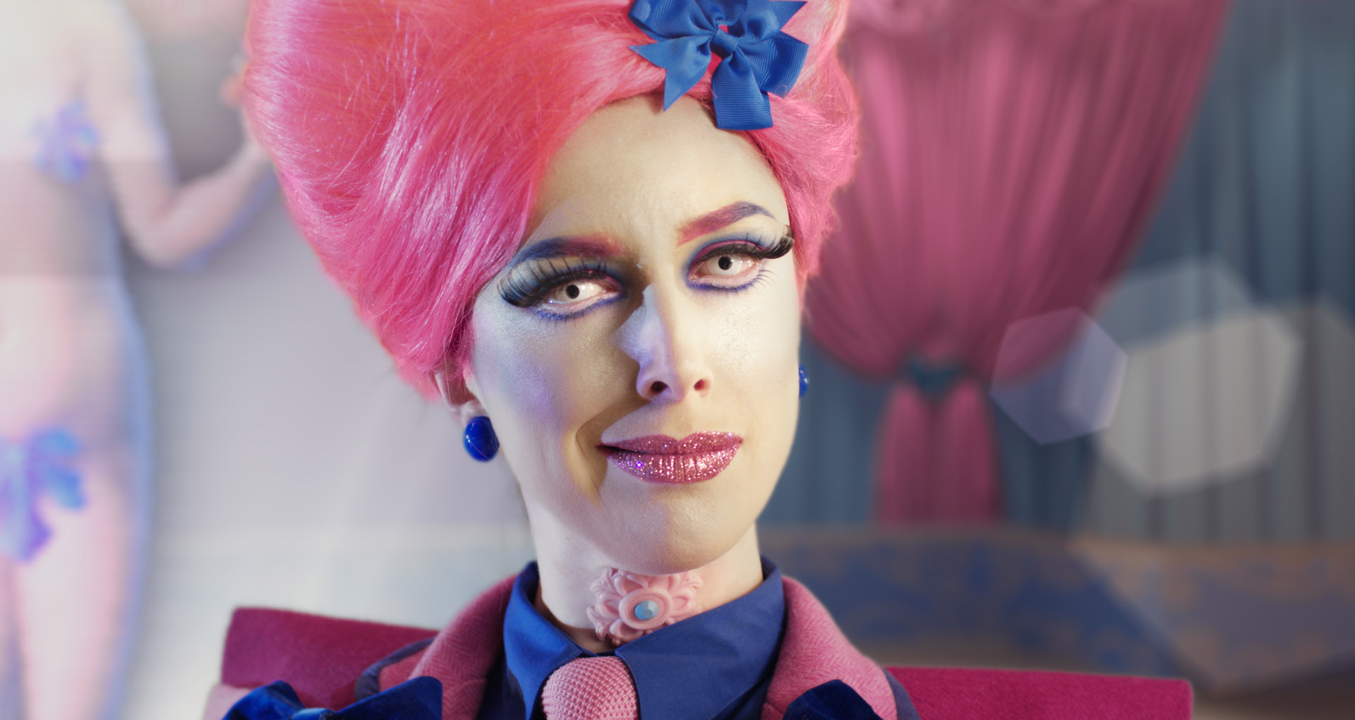 © Rachel Maclean, Make Me Up, 2018 Image aux couleurs saturées, une femme avec une perruque rose en grosplan